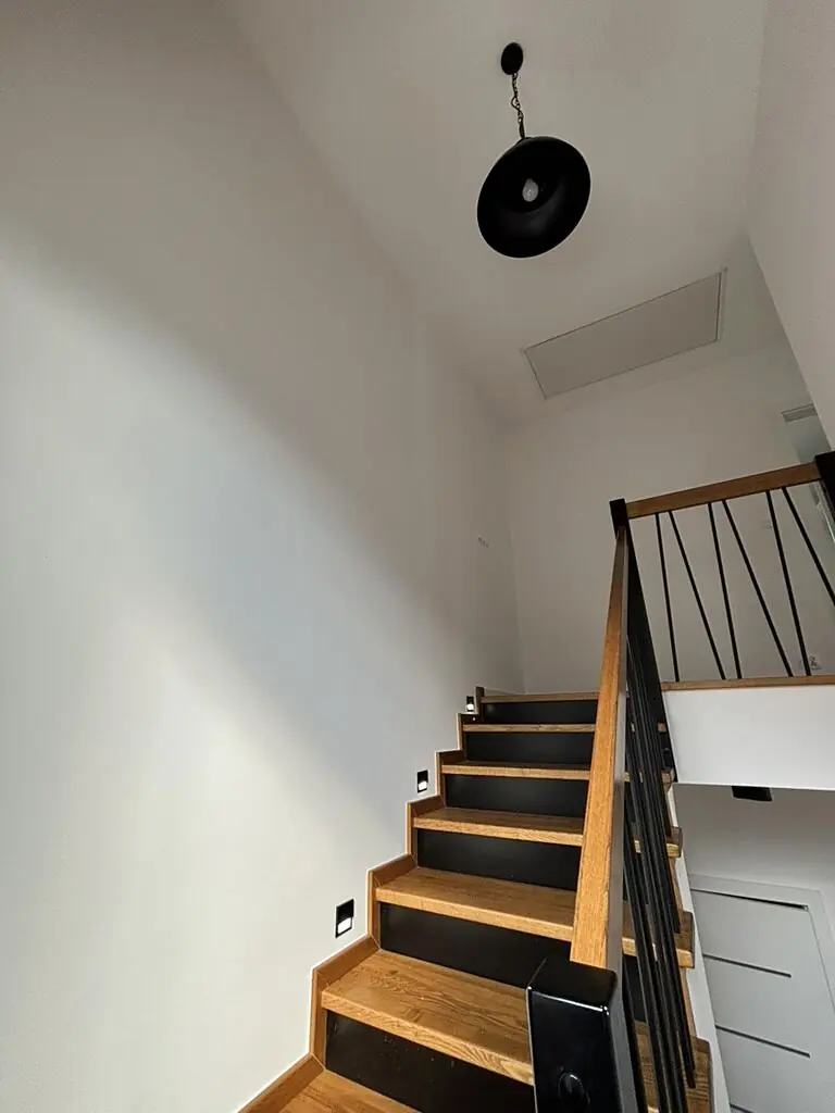 Schody z czarną lampą wiszącą