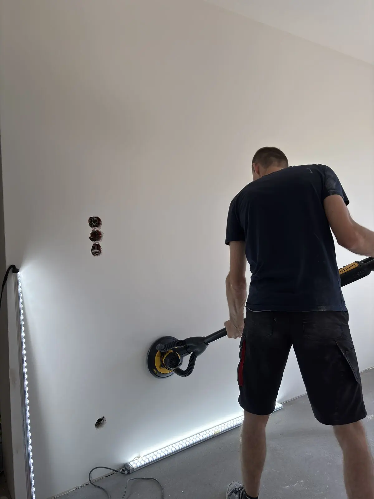 Szlifowanie ściany sprzętem bezpyłowym przy oświetleniu smugowym LED
